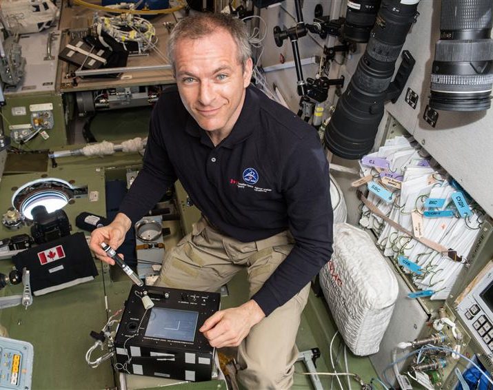 Astronaut David St Jaques conducting experiments using a bubble detector on the international space station.
