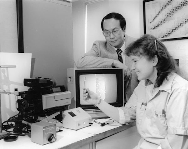 Dr. Harry Ing and a technician look on at his latest invention, the 